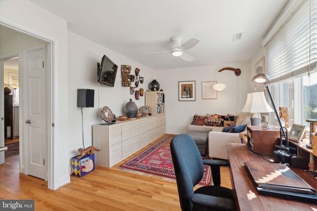 home office with ceiling fan and light hardwood / wood-style floors