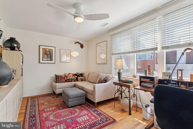 living room featuring light wood-type flooring and ceiling fan