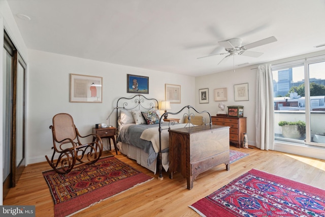 bedroom with light wood-type flooring, ceiling fan, and a closet