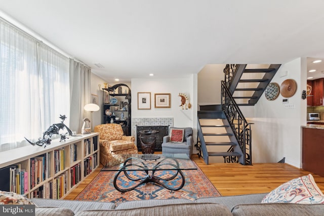 living room with hardwood / wood-style flooring and a tiled fireplace