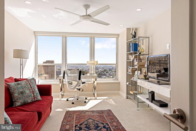 carpeted office space featuring ceiling fan