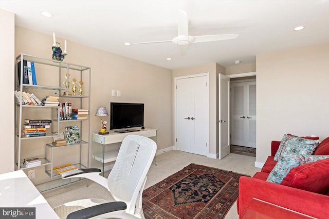 carpeted home office featuring ceiling fan