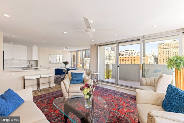 living room featuring light hardwood / wood-style floors, ceiling fan, and sink