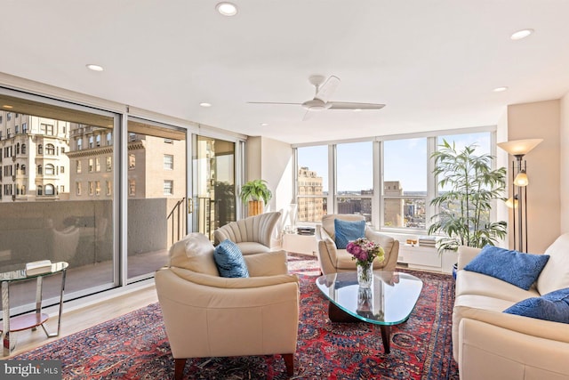 living room with ceiling fan, floor to ceiling windows, and light hardwood / wood-style floors