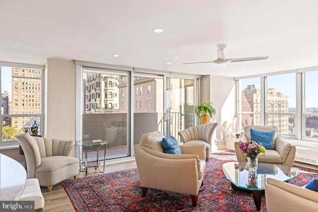 interior space with light hardwood / wood-style floors, ceiling fan, and expansive windows