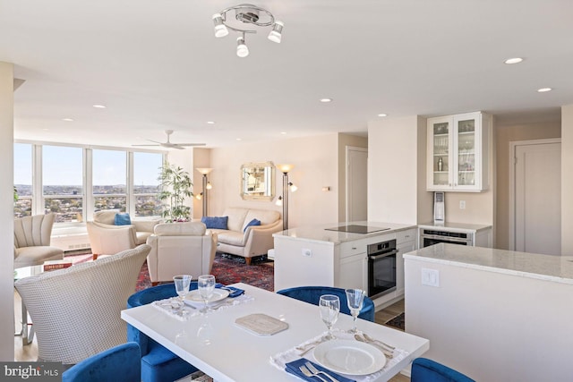 dining space featuring ceiling fan, floor to ceiling windows, and dark wood-type flooring