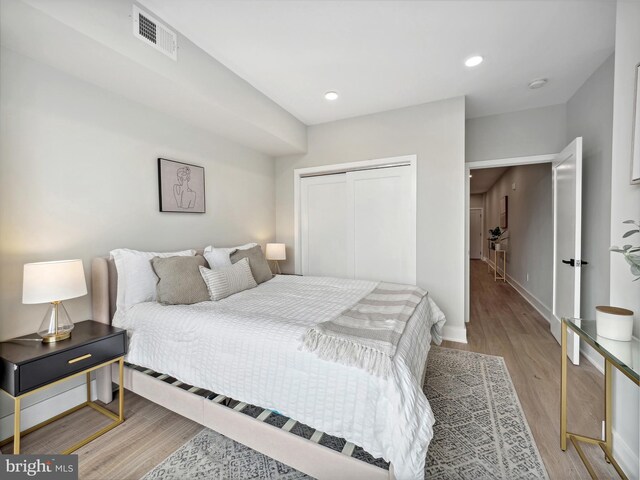 bedroom with light wood-type flooring and a closet