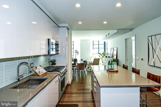 kitchen featuring white cabinets, appliances with stainless steel finishes, dark hardwood / wood-style floors, and sink