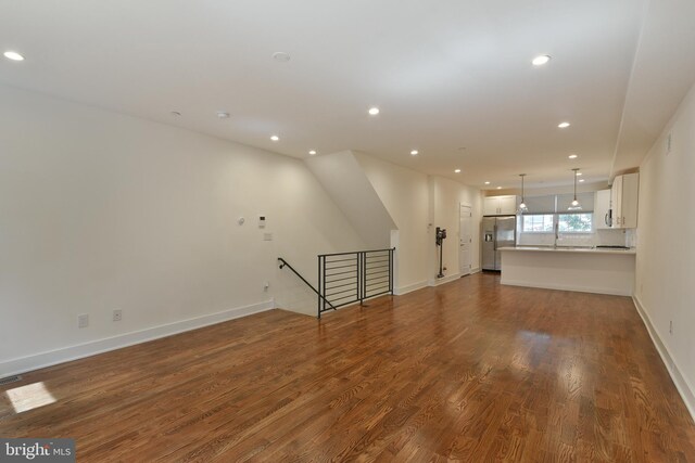 unfurnished living room featuring hardwood / wood-style floors and sink