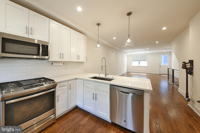 kitchen featuring appliances with stainless steel finishes, sink, dark wood-type flooring, and white cabinets