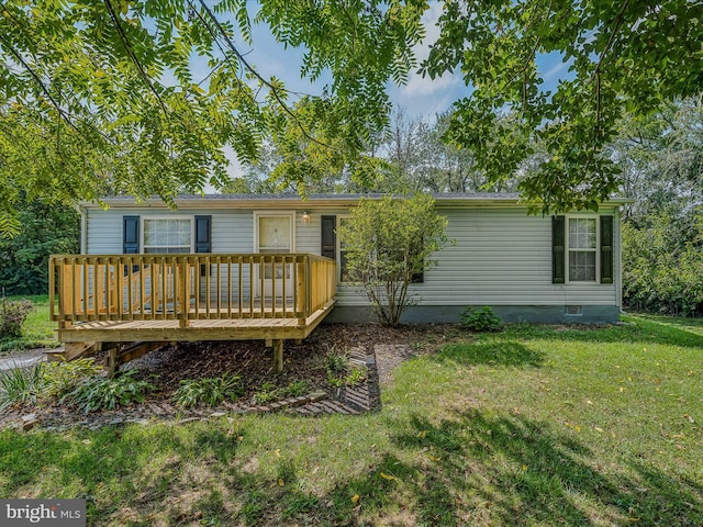 rear view of house featuring a lawn and a deck