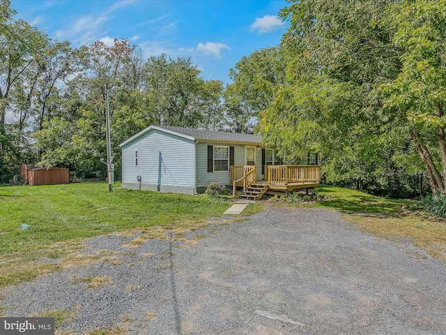 manufactured / mobile home with a front yard and a wooden deck