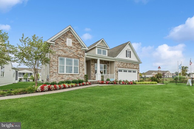 craftsman house with a garage, a front yard, and a porch