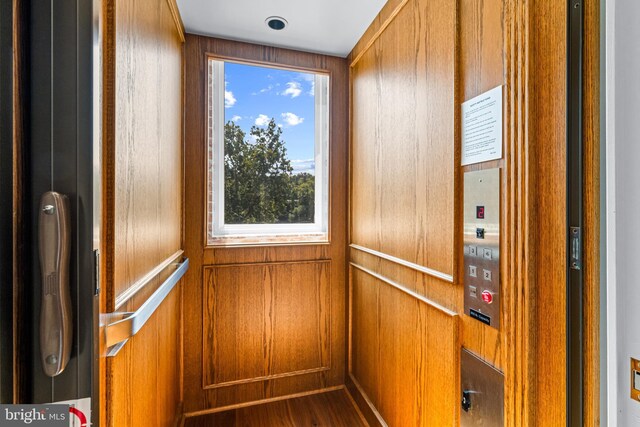 room details with elevator and hardwood / wood-style flooring