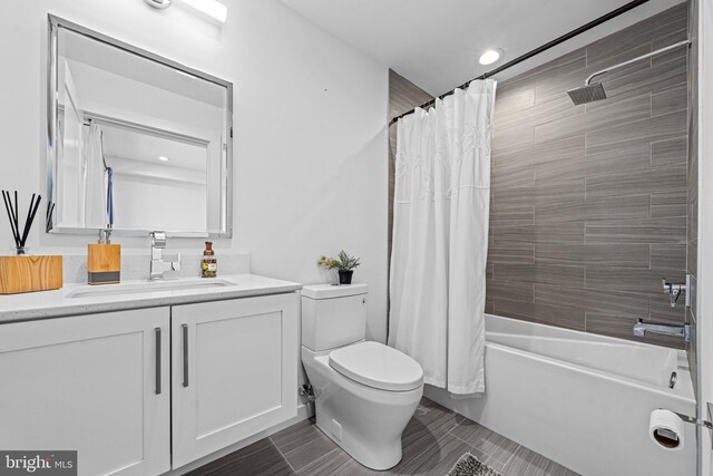 full bathroom with shower / tub combo with curtain, vanity, and toilet