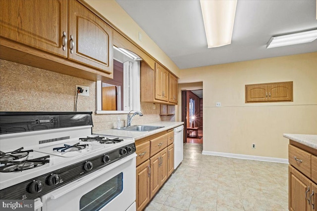 kitchen with backsplash, sink, light tile patterned floors, and white appliances