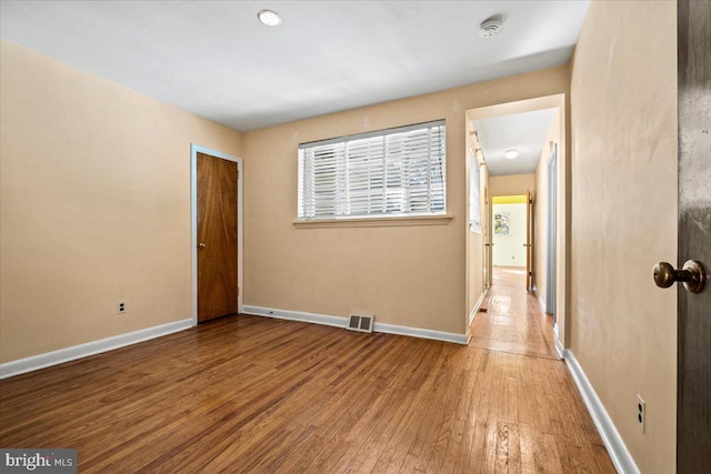 empty room with hardwood / wood-style floors