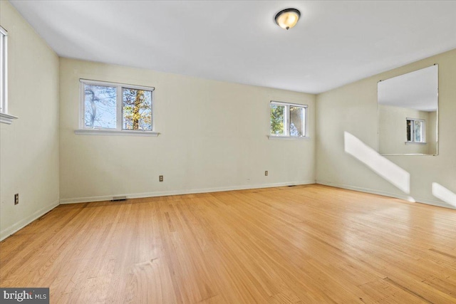 empty room featuring a wealth of natural light and light wood-type flooring