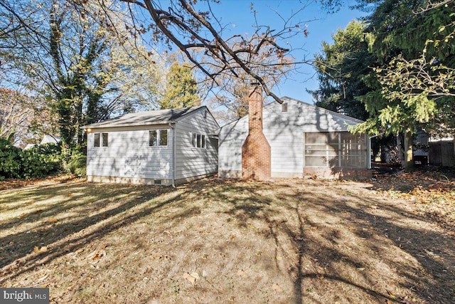 view of side of property featuring a yard and a sunroom