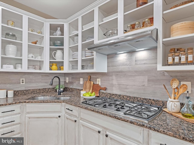 kitchen featuring stainless steel gas stovetop, backsplash, sink, and white cabinetry