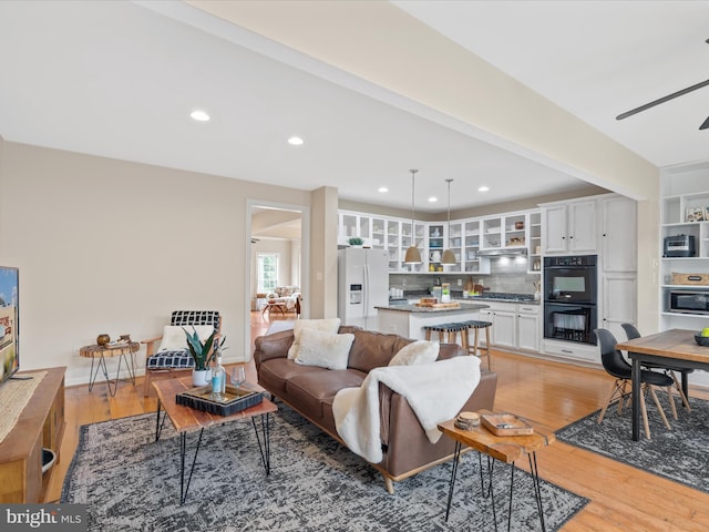 living room featuring ceiling fan and light hardwood / wood-style floors