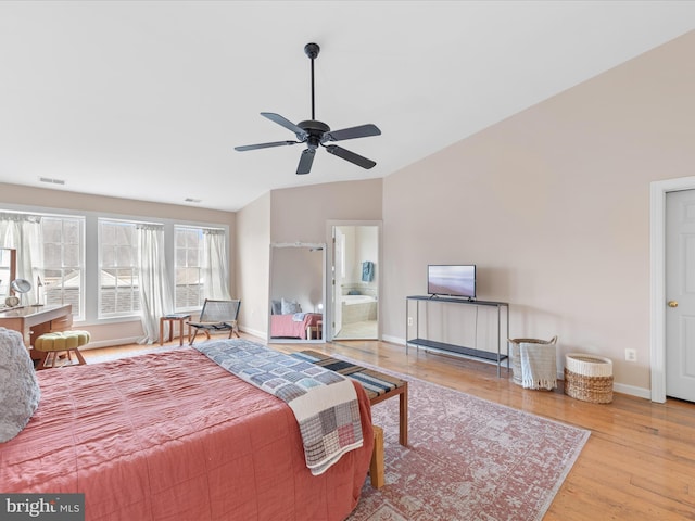 bedroom featuring lofted ceiling, light hardwood / wood-style floors, ensuite bathroom, and ceiling fan