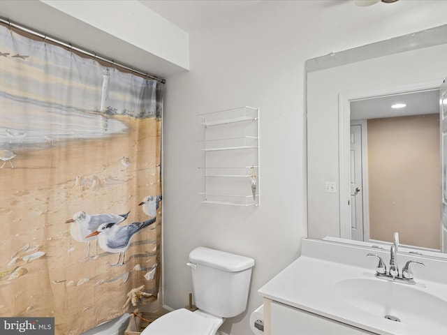 bathroom with walk in shower, vanity, and toilet