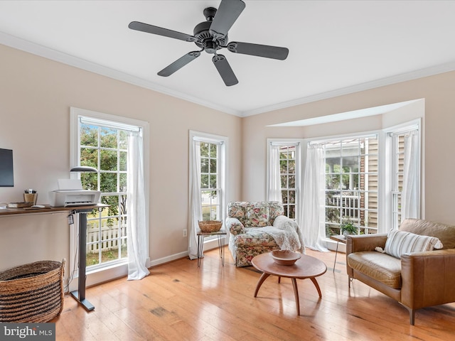 sitting room with ceiling fan, ornamental molding, light hardwood / wood-style floors, and a wealth of natural light