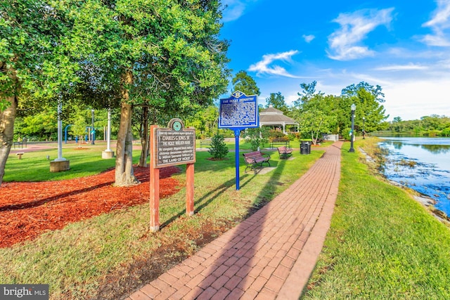 surrounding community featuring a lawn and a water view