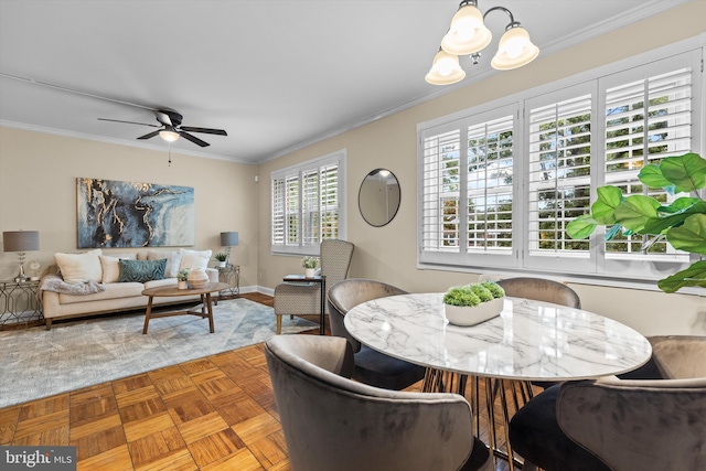 dining room featuring light parquet flooring, ceiling fan with notable chandelier, and ornamental molding