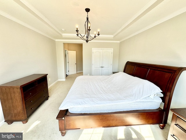 bedroom with an inviting chandelier, light carpet, a closet, a tray ceiling, and crown molding