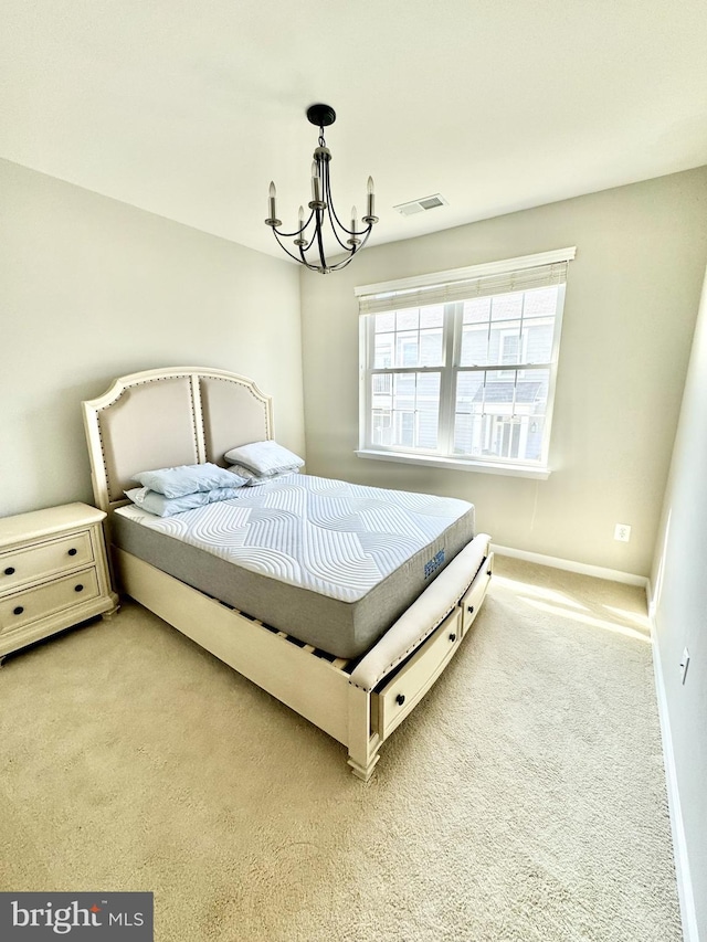 bedroom featuring an inviting chandelier and light carpet