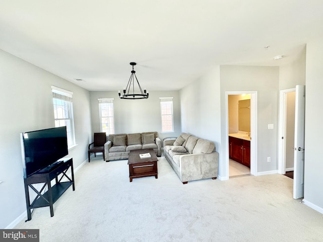 carpeted living room with a chandelier