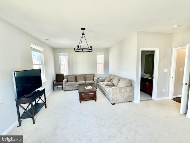 living room with a notable chandelier and light carpet