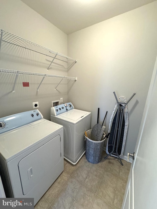 washroom with washer and dryer and light tile patterned floors