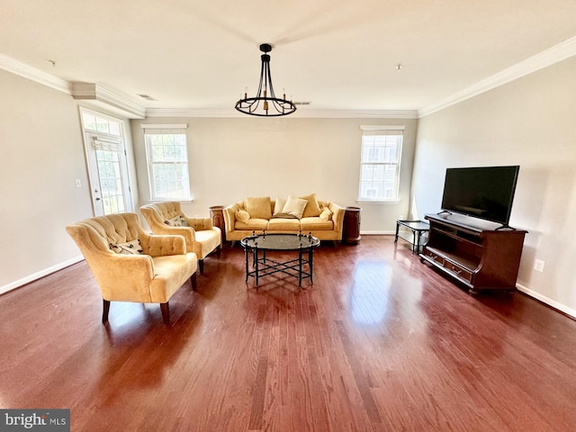 living room featuring ornamental molding, a healthy amount of sunlight, an inviting chandelier, and dark hardwood / wood-style floors