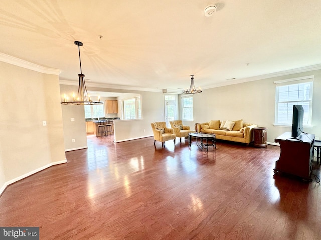 living room featuring crown molding, dark wood-type flooring, and a chandelier