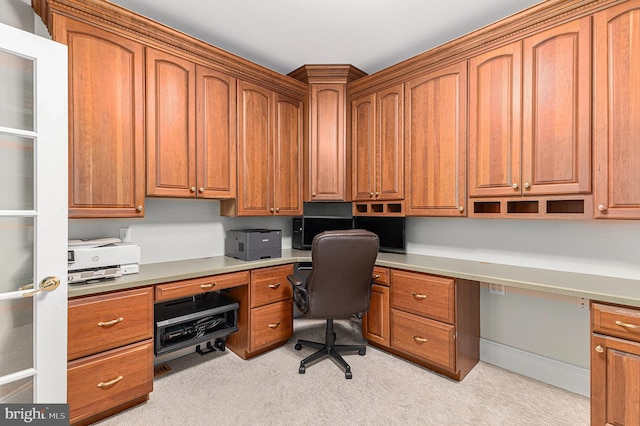 office area with built in desk and light colored carpet