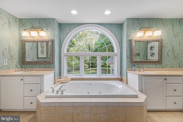 bathroom with tiled bath, vanity, and tile patterned flooring