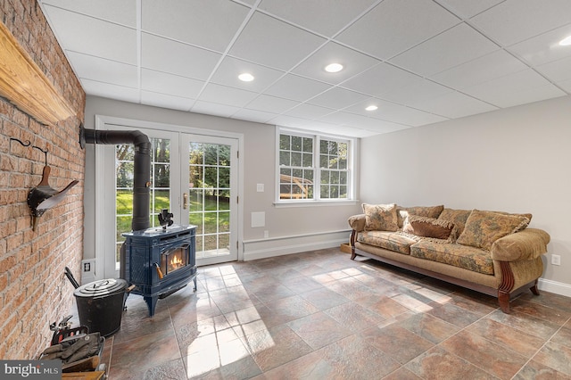 living room featuring a drop ceiling and a wood stove