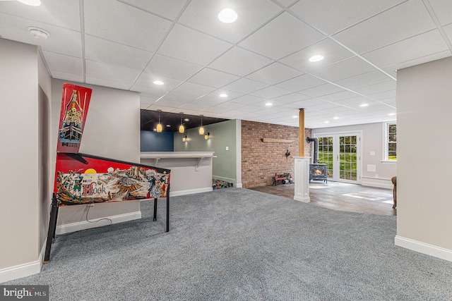 interior space with a wood stove and a paneled ceiling