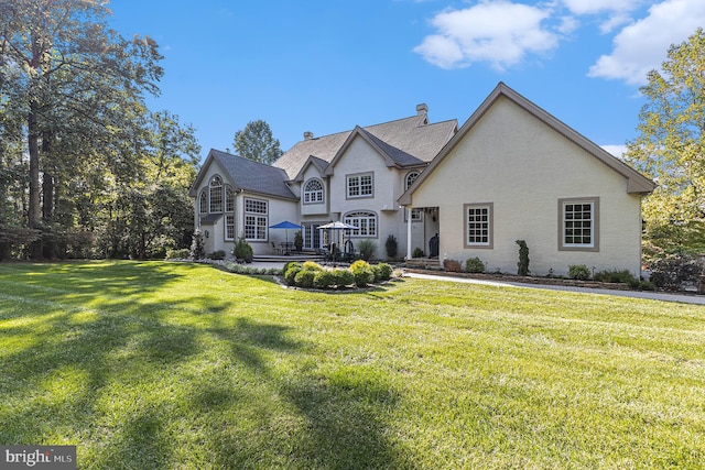 french country home with a wooden deck and a front yard