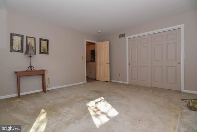 unfurnished bedroom with light carpet and a closet