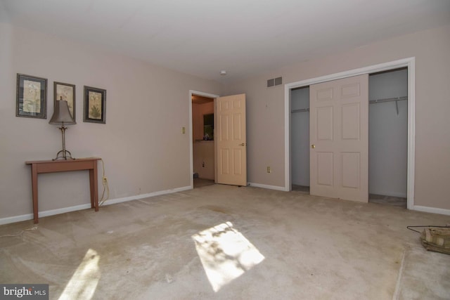 unfurnished bedroom with light carpet and a closet