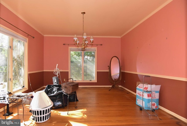 dining area with a notable chandelier, hardwood / wood-style flooring, and ornamental molding