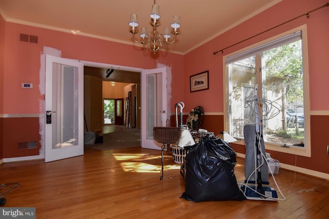 dining room with ornamental molding, wood-type flooring, and a chandelier