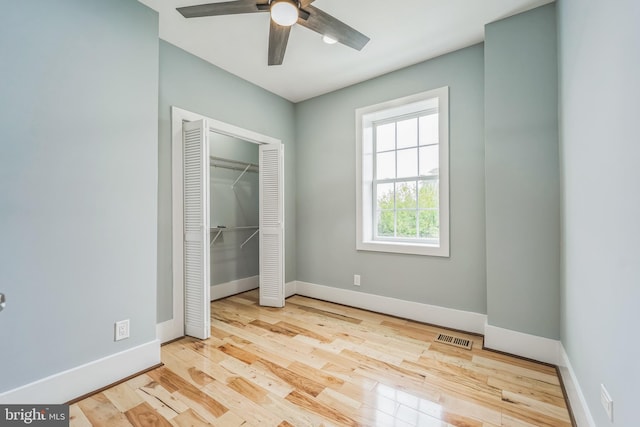 unfurnished bedroom with light hardwood / wood-style floors, ceiling fan, and a closet