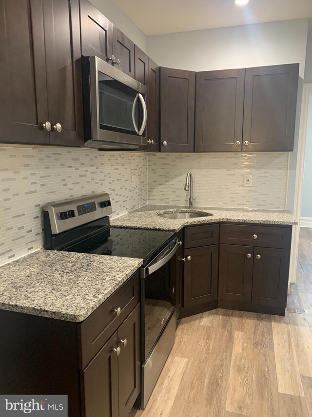 kitchen with light wood-type flooring, ceiling fan, appliances with stainless steel finishes, and dark brown cabinetry