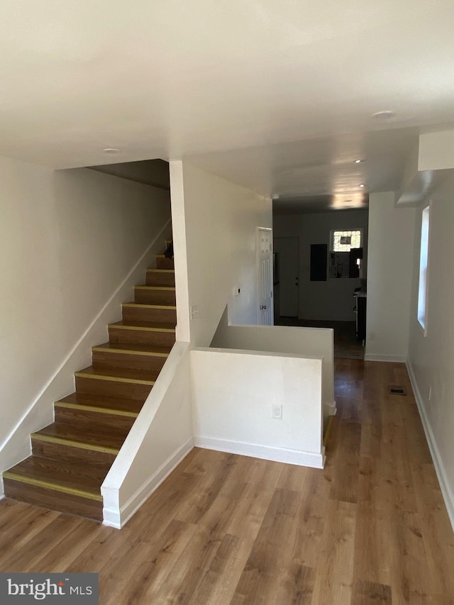 stairs featuring hardwood / wood-style floors