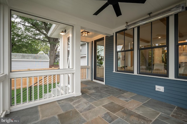 unfurnished sunroom with ceiling fan